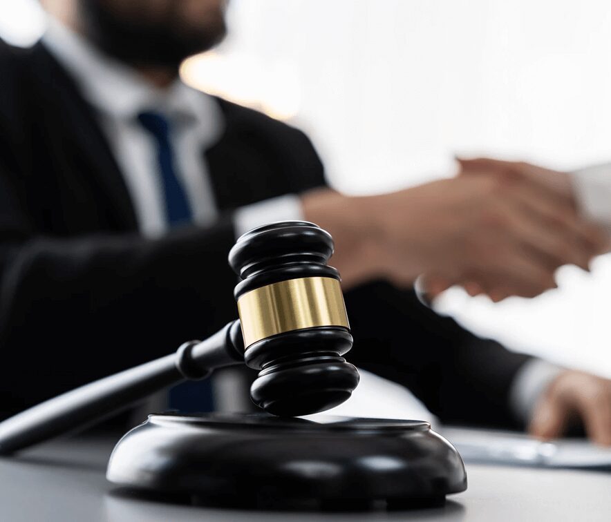 A judge's gavel with a lawyer and client shaking hands in the background, symbolizing case resolution